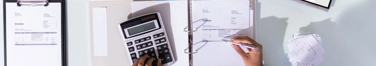 Contabile con calcolatrice e fogli di calcolo, simbolo del ruolo di merchant of records nella gestione finanziaria delle vendite online.