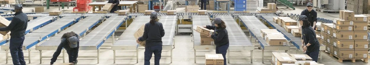Addetti alla logistica davanti a un impianto logistico mentre svolgono le loro attività operative.